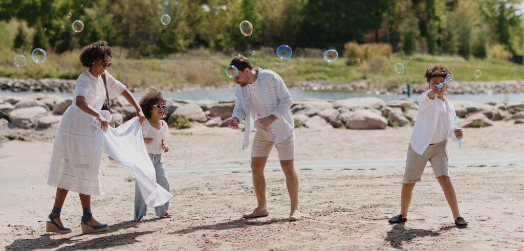 Family playing on beach with bubbles 