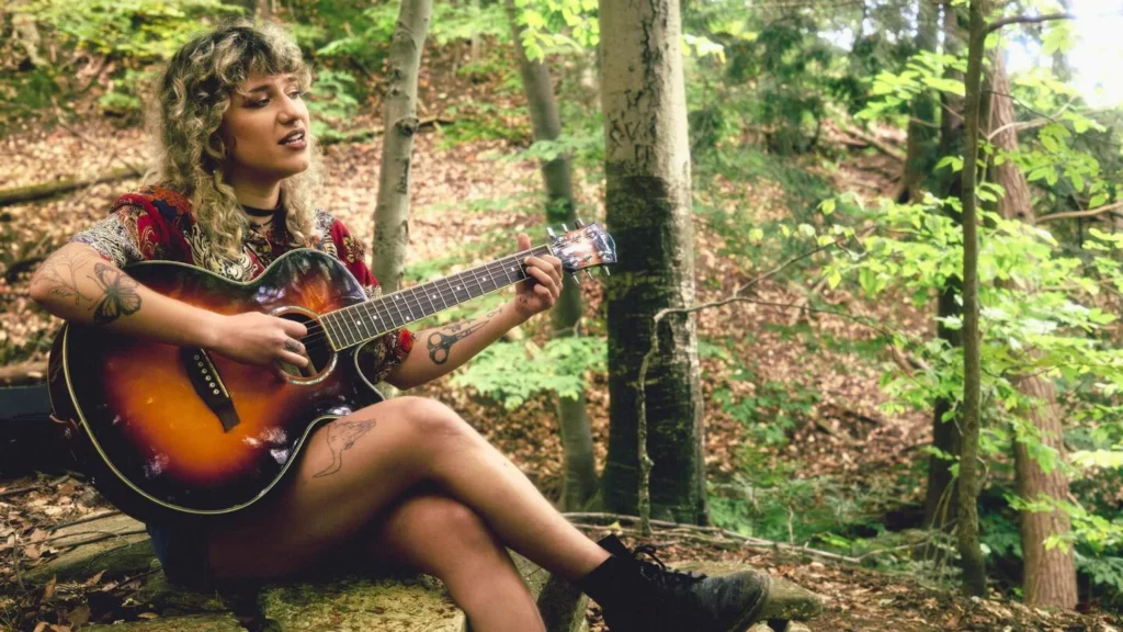 Artist playing the guitar in the Trails of Blue Mountain.